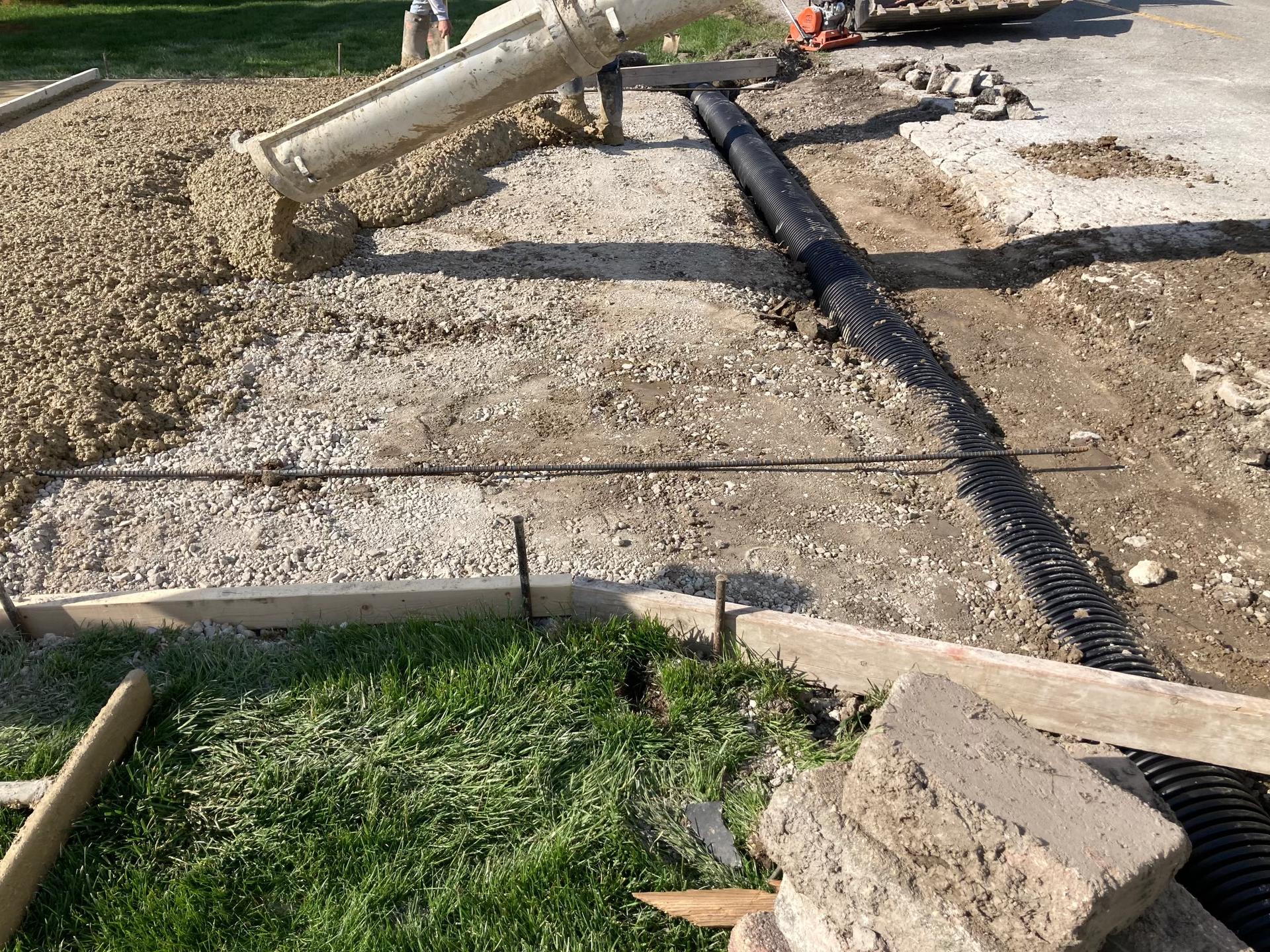 Driveway pour in progress (pump truck + drainage pipe), Anderson Indiana
